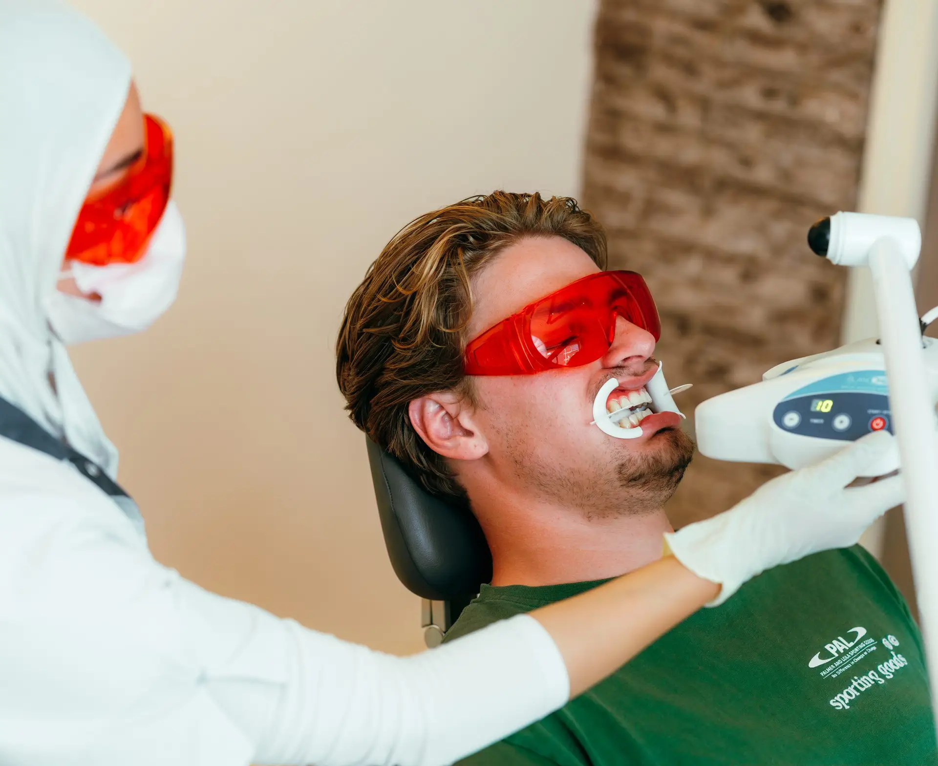 Mondhygiënist behandelt een patiënt voor het bleken van de tanden