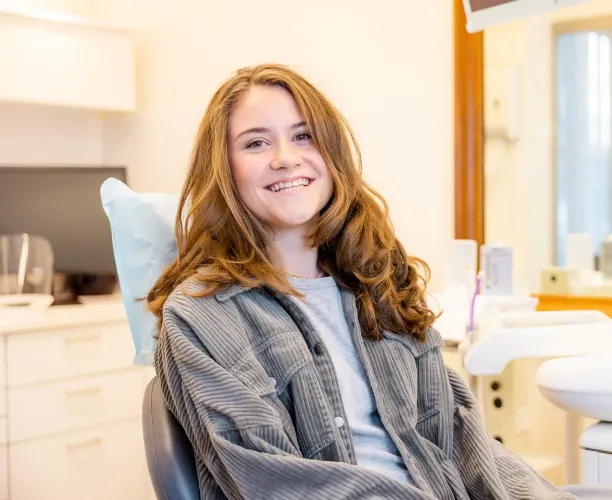 Patiënt met een glimlach tijdens een tandheelkundige behandeling